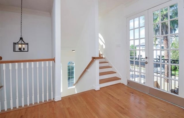 entryway with french doors, hardwood / wood-style floors, a notable chandelier, and a healthy amount of sunlight