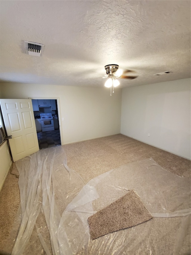 interior space with a textured ceiling and ceiling fan