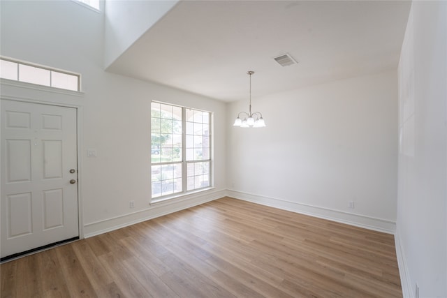 entryway featuring plenty of natural light, a chandelier, and light hardwood / wood-style flooring