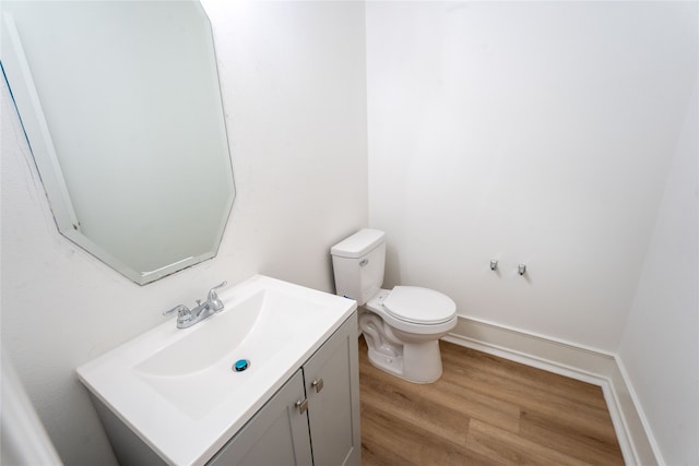 bathroom featuring vanity, toilet, and hardwood / wood-style floors