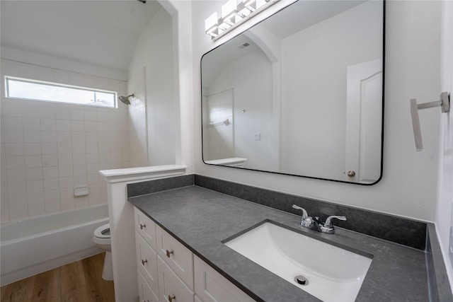 full bathroom with tiled shower / bath, vanity, toilet, and hardwood / wood-style flooring