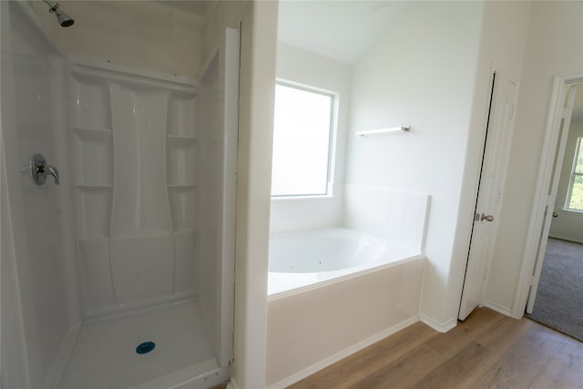 bathroom with lofted ceiling, a wealth of natural light, hardwood / wood-style floors, and separate shower and tub