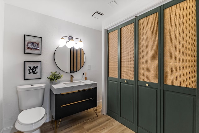 bathroom with wood-type flooring, toilet, and vanity