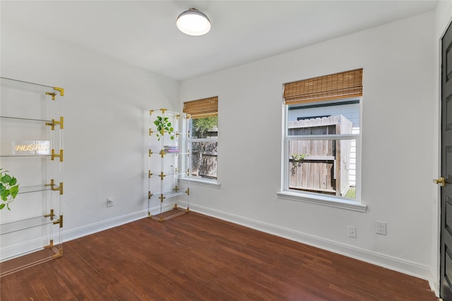 unfurnished room with dark wood-type flooring