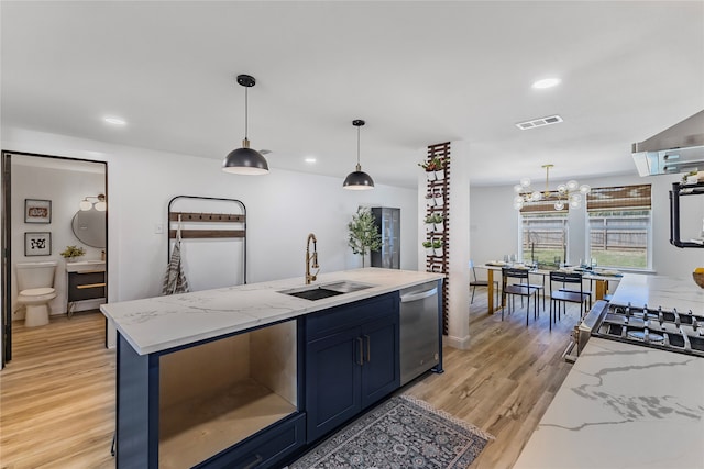 kitchen with pendant lighting, light stone counters, sink, and appliances with stainless steel finishes