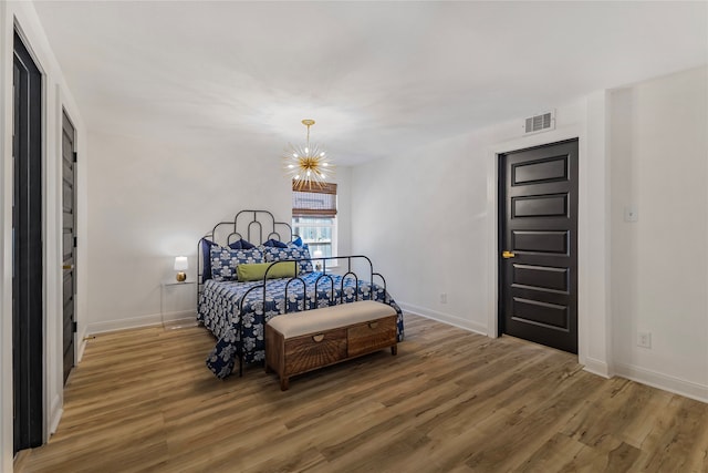 bedroom with a chandelier and wood-type flooring