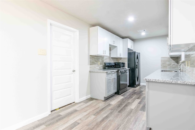 kitchen featuring light hardwood / wood-style flooring, stainless steel appliances, sink, and light stone countertops