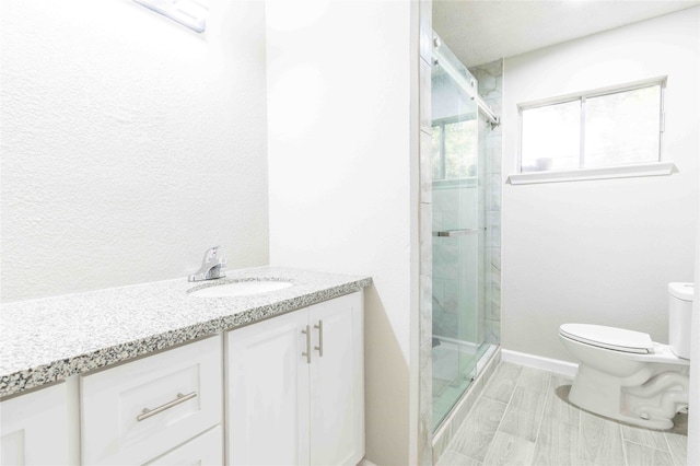 bathroom featuring vanity, toilet, and walk in shower