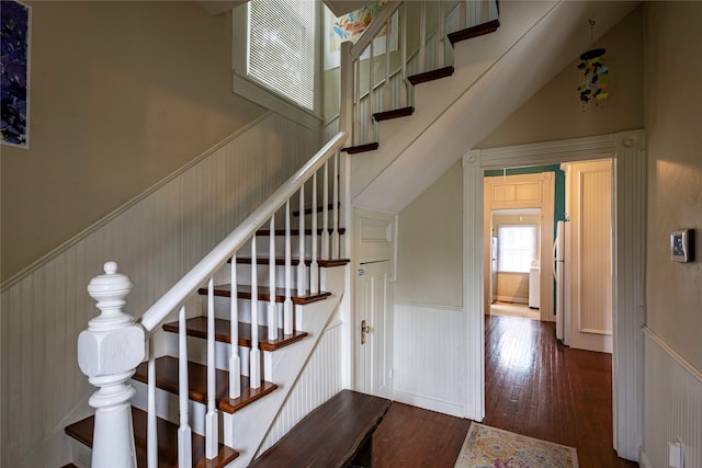 staircase with vaulted ceiling and wood-type flooring