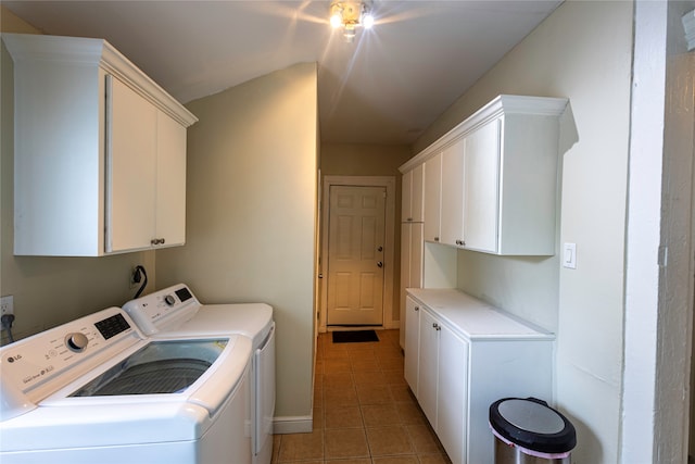 laundry area with washing machine and clothes dryer, cabinets, and tile patterned floors