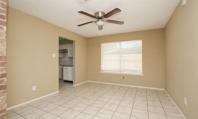 tiled empty room with a textured ceiling and ceiling fan