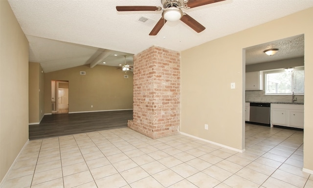 empty room featuring a textured ceiling, light hardwood / wood-style flooring, sink, ceiling fan, and vaulted ceiling with beams