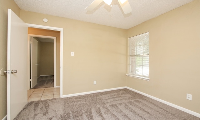 carpeted spare room with a textured ceiling and ceiling fan