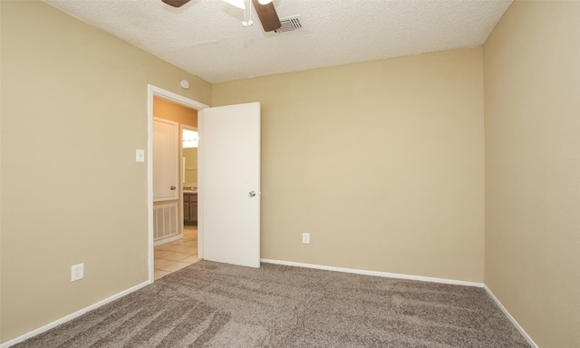 carpeted empty room featuring ceiling fan and a textured ceiling