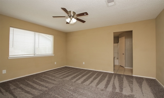 spare room with light colored carpet, ceiling fan, and a textured ceiling