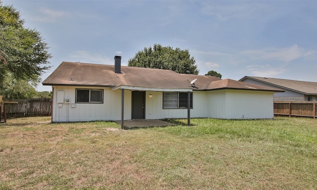 rear view of property with a lawn