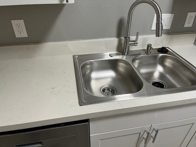 room details featuring white cabinets and sink