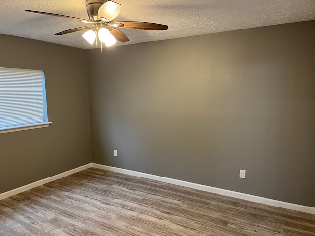 spare room with a textured ceiling, ceiling fan, and wood-type flooring