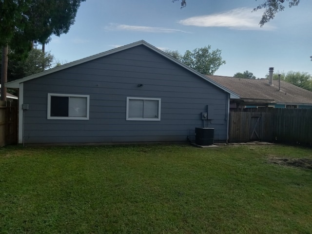 back of property with a lawn and central air condition unit