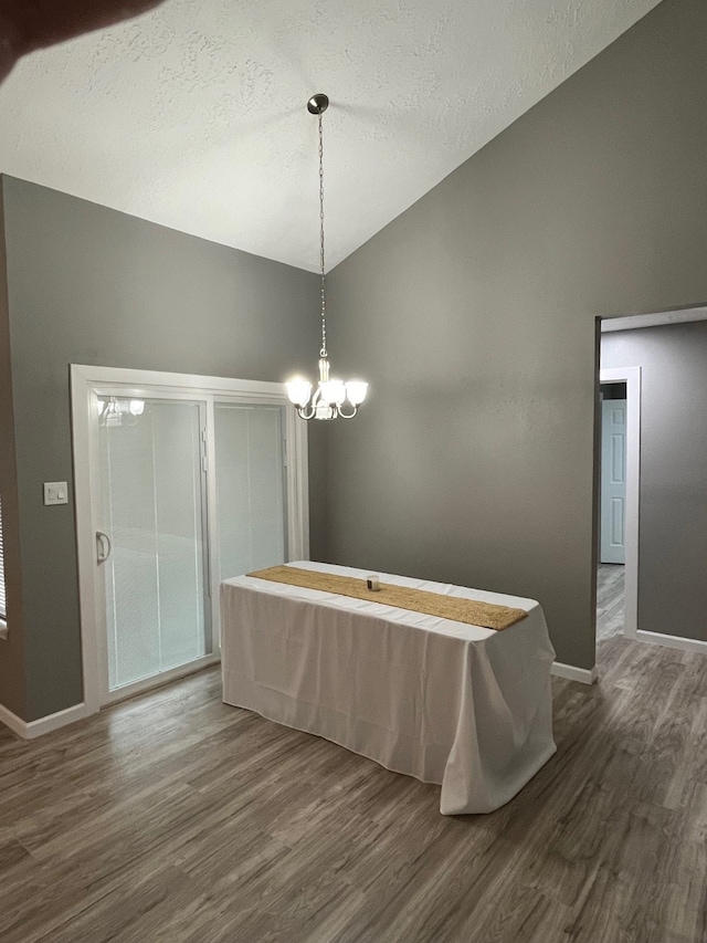 dining area featuring dark hardwood / wood-style floors, a chandelier, and a textured ceiling