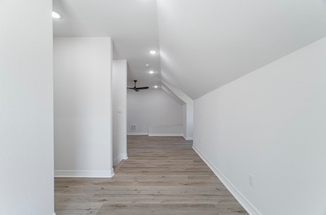 hallway featuring light wood-type flooring and lofted ceiling