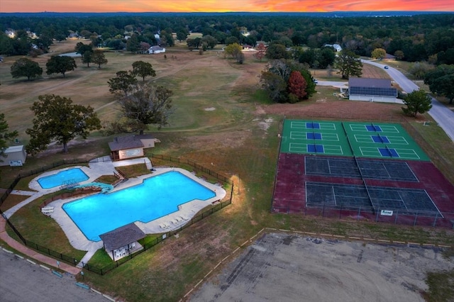 pool at dusk featuring a patio