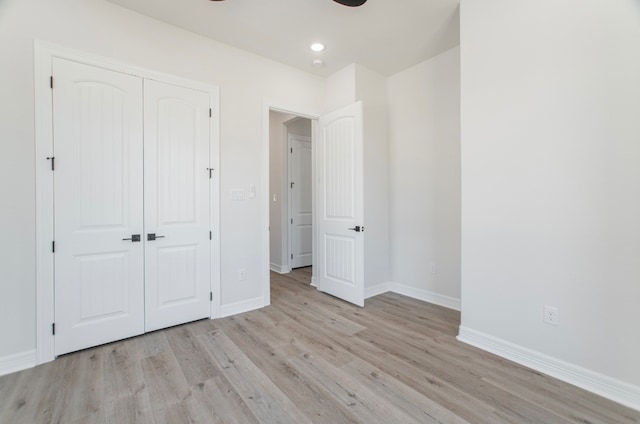 unfurnished bedroom with a closet and light hardwood / wood-style floors