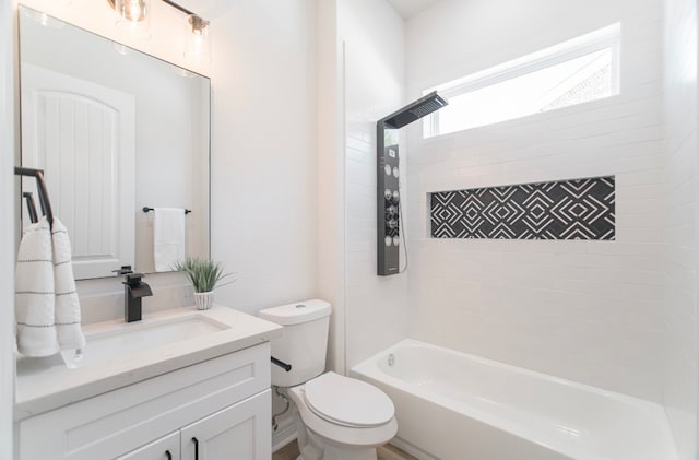 full bathroom featuring tiled shower / bath, vanity, and toilet