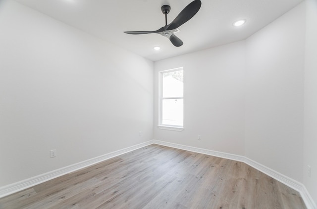 empty room with ceiling fan and light hardwood / wood-style flooring