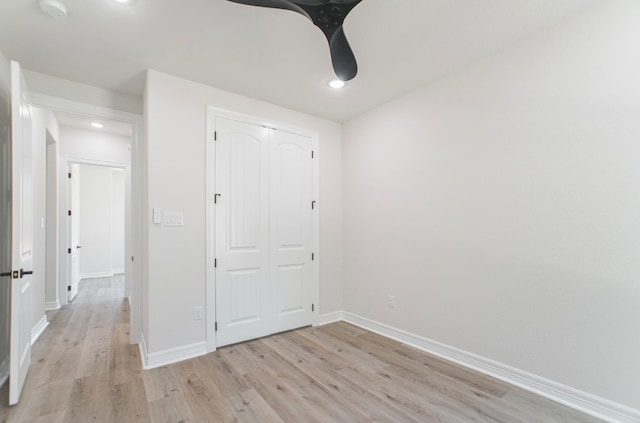 unfurnished bedroom featuring light hardwood / wood-style flooring, ceiling fan, and a closet