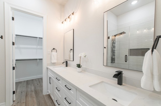 bathroom with hardwood / wood-style floors, an enclosed shower, and vanity