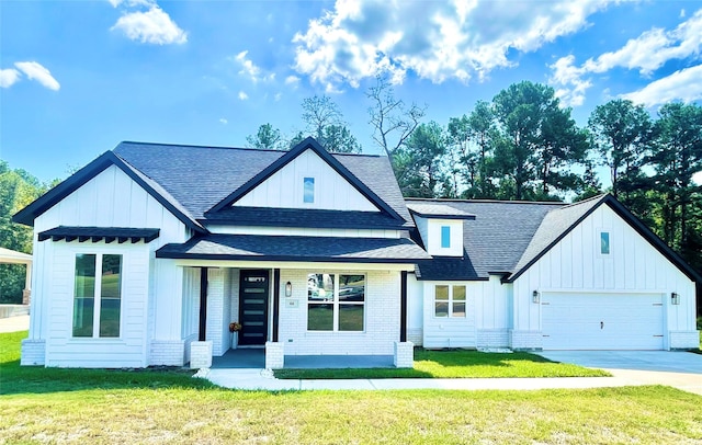 modern farmhouse featuring driveway, board and batten siding, roof with shingles, a front yard, and brick siding