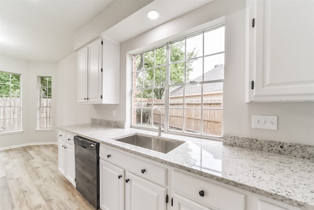 kitchen featuring light stone countertops, black dishwasher, light hardwood / wood-style floors, sink, and white cabinetry