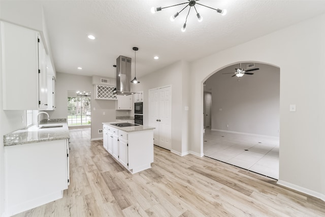 kitchen featuring pendant lighting, light wood-type flooring, white cabinetry, and island exhaust hood