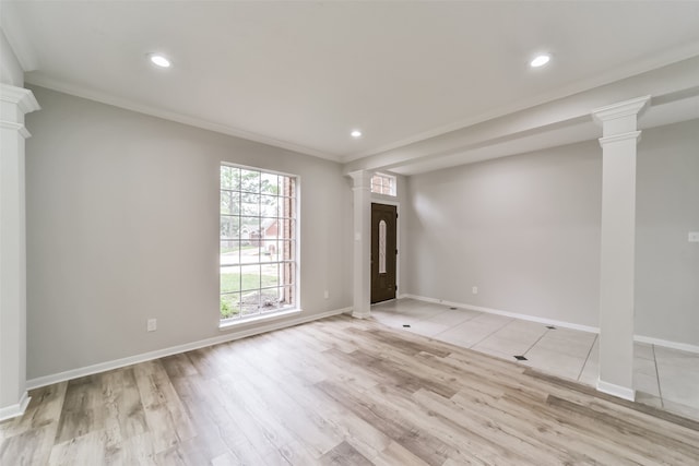 empty room with ornamental molding, light wood-type flooring, and ornate columns