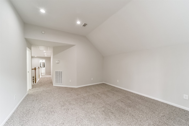 additional living space featuring lofted ceiling and light carpet