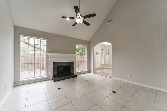 unfurnished living room with a wealth of natural light, light tile patterned floors, and ceiling fan