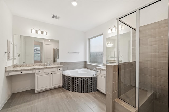 bathroom with vanity, hardwood / wood-style flooring, and independent shower and bath