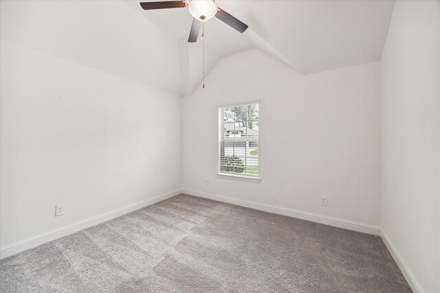 carpeted empty room featuring vaulted ceiling and ceiling fan