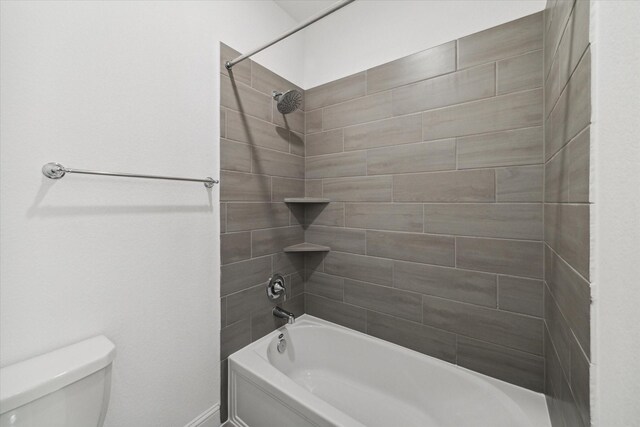 bathroom featuring toilet and tiled shower / bath combo