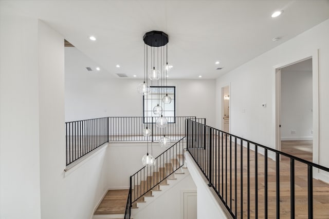 hallway featuring hardwood / wood-style floors and a chandelier