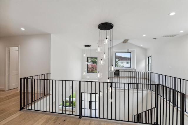 hallway featuring light wood-type flooring and vaulted ceiling