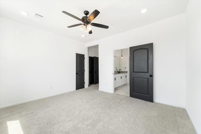 unfurnished bedroom with ceiling fan, connected bathroom, and sink