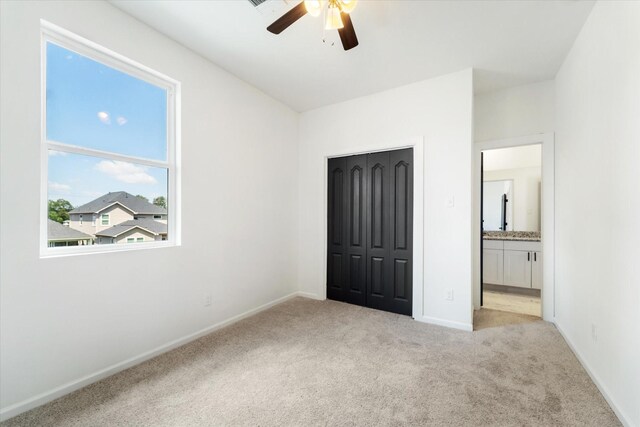 unfurnished bedroom with a closet, ceiling fan, and light colored carpet