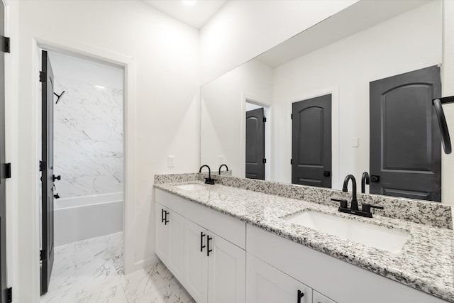 bathroom with tiled shower / bath combo and vanity