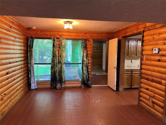 tiled spare room with rustic walls and a textured ceiling