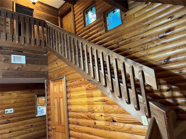 staircase with rustic walls and a towering ceiling