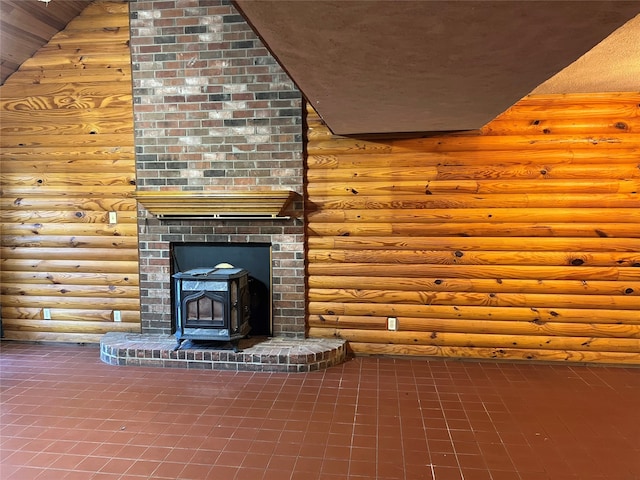 unfurnished living room with lofted ceiling, tile patterned flooring, a wood stove, and rustic walls