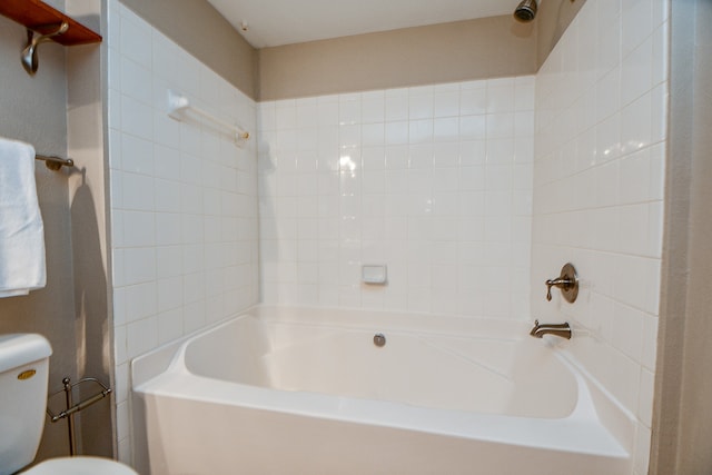 bathroom with tiled shower / bath and toilet