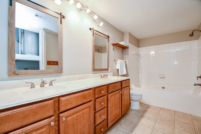 full bathroom featuring tile patterned flooring, tiled shower / bath, toilet, and vanity